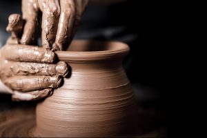 Hands of potter making clay pot